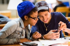 (21) Students looking at phone in Grainger Engineering Library.